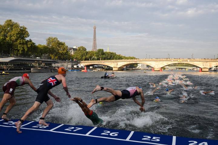 Triathlon athletes dive in the Seine river during the men's 2023 World Triathlon Olympic Games test event in Paris on August 18, 2023.